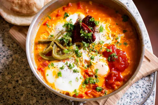 Shakshouka with red peppers & tomato paste, eggs, ras-el-hanout, chipotle peppers and pickled nopales, salsa