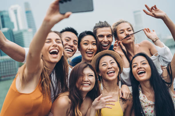 grand groupe multiethnique de jeunes faisant le selfie - photographing smart phone friendship photo messaging photos et images de collection