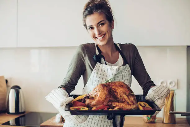 Photo of Young woman prepared a stuffed turkey