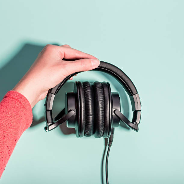 istock Black overhead headphones neon background, copy space. Modern technology flat lay with over-ear earphones and cable, modern lifestyle gadget concept 1227253754