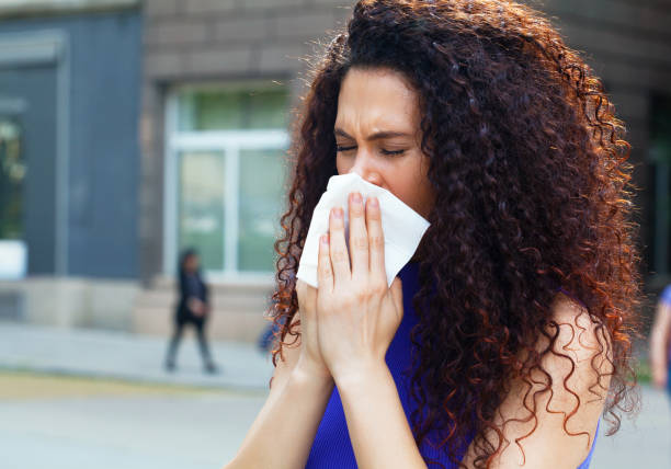 istock Sick young woman blowing her nose 1227259491