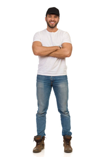 Confident Smiling Man In Black Cap Is Standing With Arms Crossed