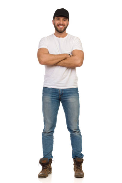 Confident Smiling Man In Black Cap Is Standing With Arms Crossed stock photo