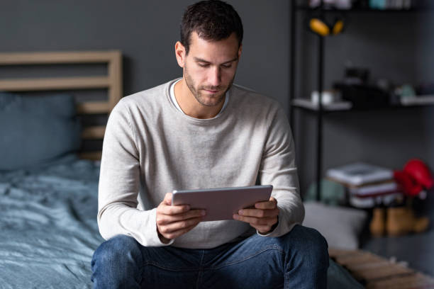 istock Young Handsome Caucasian Man Using a Digital Tablet at Home 1227261767