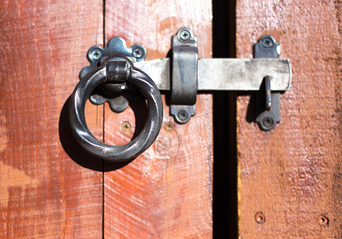 Isolated photo of old fashioned rusty steel door handles with keyhole on white background.