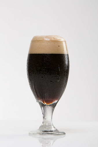 Chocolate craft beer, dark brown ale, in beer glass, isolated on White background, shot in the studio