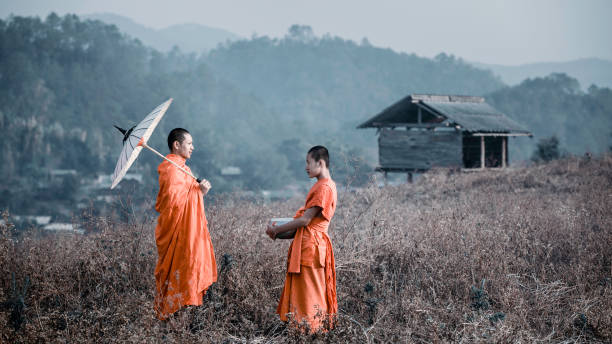 istock The monks are standing teaching a novice on the meadow. 1227269316