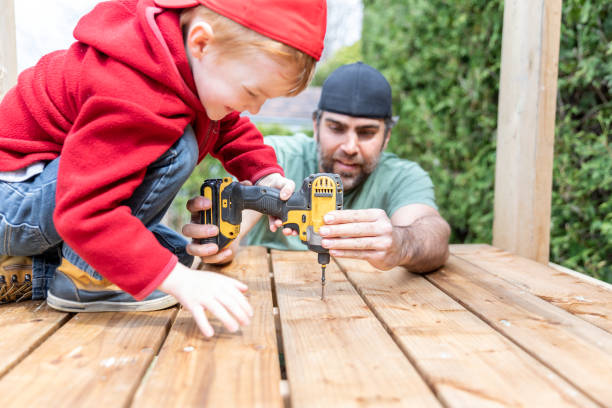 Father and Son Doing a Construction Project While In Quarantine A father and his redhead boy son are doing a construction project while quarantined during the Covid-19 pandemic. The cute kid is drilling and the father is holding the drill to help him. The father is teaching his son how to build a tree house. They are bonging and spending quality time together during Father’s day. fathers day tools stock pictures, royalty-free photos & images