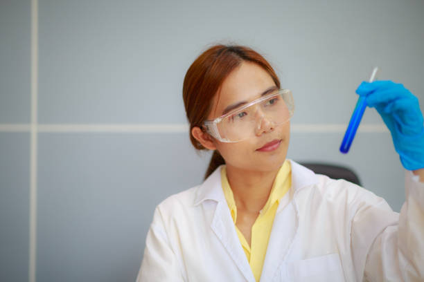 scienziato da primo piano che tiene il tubo conico con soluzione liquida, esperimenti di laboratorio - test tube biologist laboratory beaker foto e immagini stock