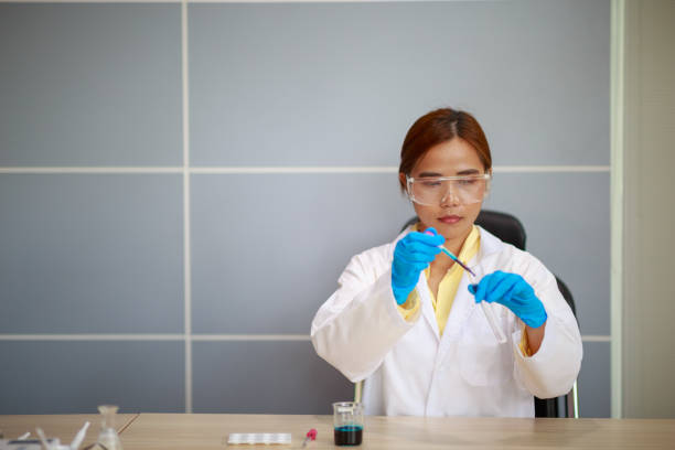 scienziato da primo piano che tiene il tubo conico con soluzione liquida, esperimenti di laboratorio - test tube biologist laboratory beaker foto e immagini stock