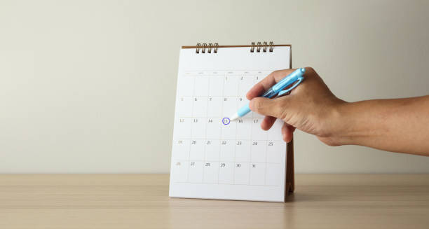 istock Hand with pen mark at 15th on calendar date 1227272885