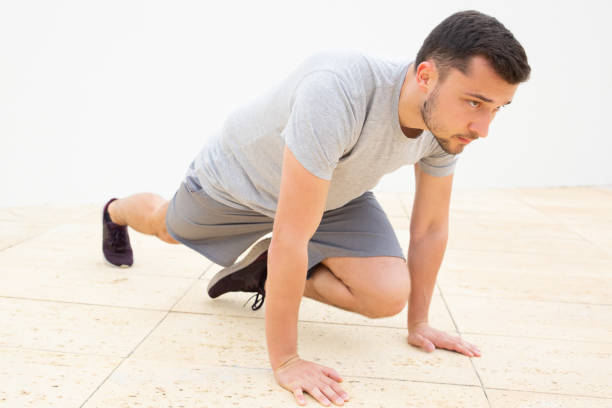 istock Attractive man in grey t-shirt doing exercise for legs 1227275603