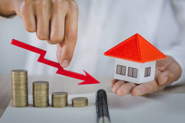 un hombre de negocios con un gráfico rojo en la moneda, inversión inmobiliaria y concepto financiero hipotecario de la casa, riesgo de inversión e incertidumbre en el mercado inmobiliario, seguros. - caida compraventa viviendas fotografías e imágenes de stock