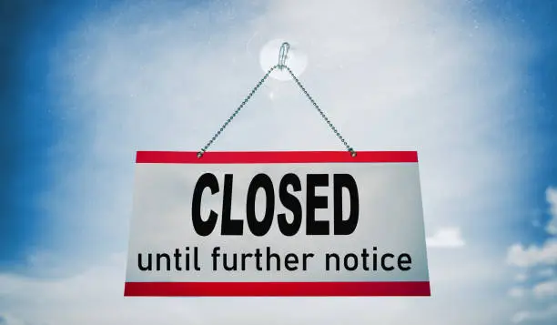 Closed businesses until further notice for COVID-19 , closure sign hanging on storefront window. Government shutdown of restaurants, stores, non essential services leading to bankruptcy unemployment.
