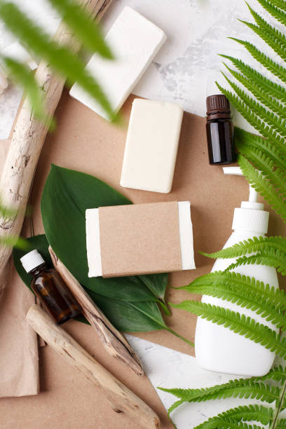 istock Zero waste natural cosmetics products on craft paper and white table. Flat lay, organic solid soap and shampoo bars, antibacterial soap dispenser, essential oils and organic detail, fern brunches 1227279850