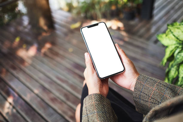 istock a woman holding a black mobile phone with blank white desktop screen 1227284278