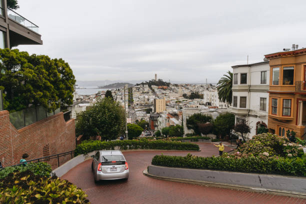 la voiture se déplace sur la rue lombarde sur la colline russe, san francisco - san francisco county lombard street street house photos et images de collection