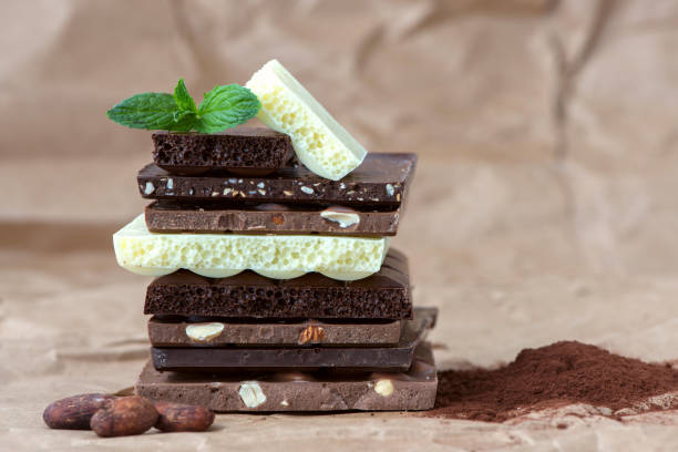 istock Different kinds of chocolates with nuts cocoa powder and mint - selective focus, wrapping brown paper background 1227288077