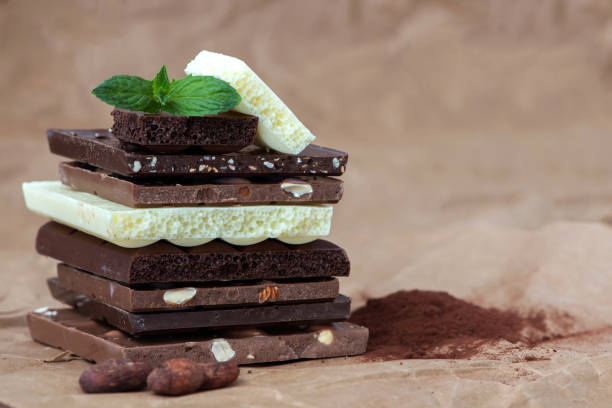 istock Different kinds of chocolates with nuts cocoa powder and mint - selective focus, wrapping brown paper background 1227289192
