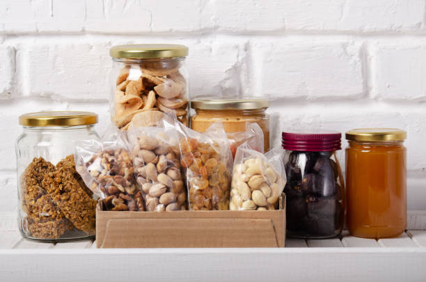 set of long storage term mostly dry sweet energy foods on pantry shelf on brick wall background - non perishable imagens e fotografias de stock