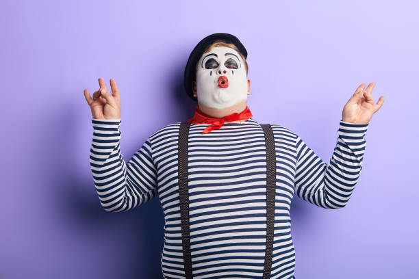 fat clown blowing his cheeks, doing yoga, reliefs stress. close up photo. isolated blue background, studio shot.
