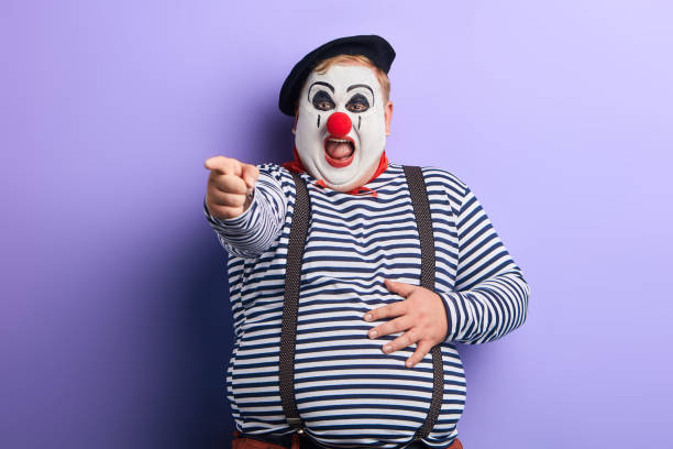 istock happy plump cheerful clown pointing at the camera nad laughing 1227292088