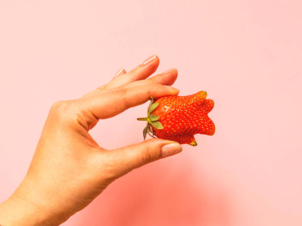 istock Ugly food: unusual strawberry in a woman hand 1227292339