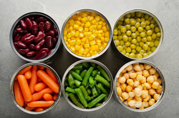 Flat lay view at canned carrots, chickpeas, kidney beans, green beans, peas and corn in opened tin cans on kitchen table. Non-perishable foods background Flat lay view at canned carrots, chickpeas, kidney beans, green beans, peas and corn in opened tin cans on kitchen table. Non-perishable foods background canned food stock pictures, royalty-free photos & images