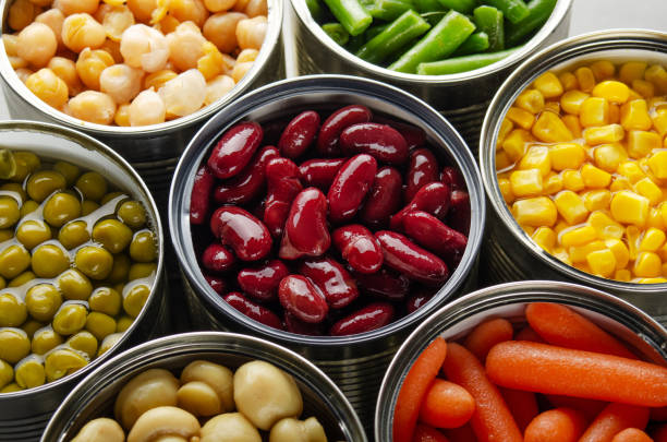 istock Canned vegetables in opened tin cans on kitchen table. Non-perishable long shelf life foods background 1227293017