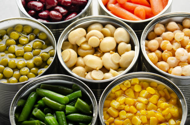 istock Canned vegetables in opened tin cans on kitchen table. Non-perishable long shelf life foods background 1227293035