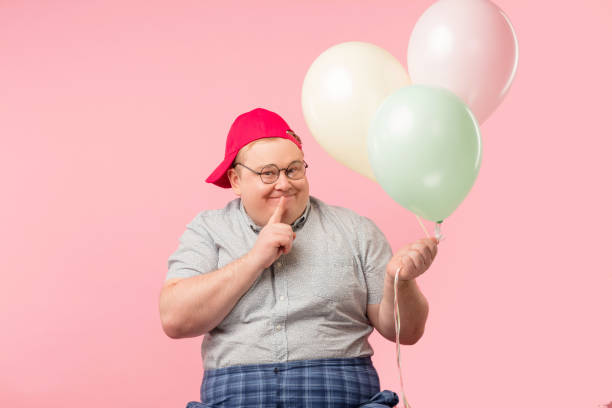 istock Surprised plump man with bugged eyes and rounded mouth, holding air balloons 1227293367