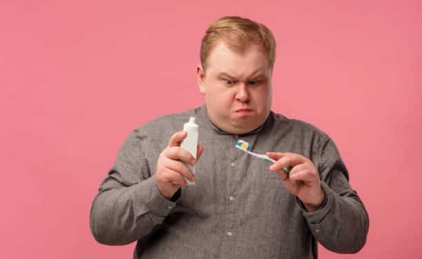 istock Emotional displeased and bewildered man brushing teeth with a new tooth paste. 1227294864