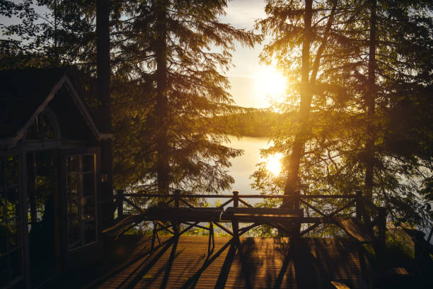 vue sur le lac au coucher du soleil depuis un chalet d’été typique avec sauna en finlande. - finland sauna lake house photos et images de collection