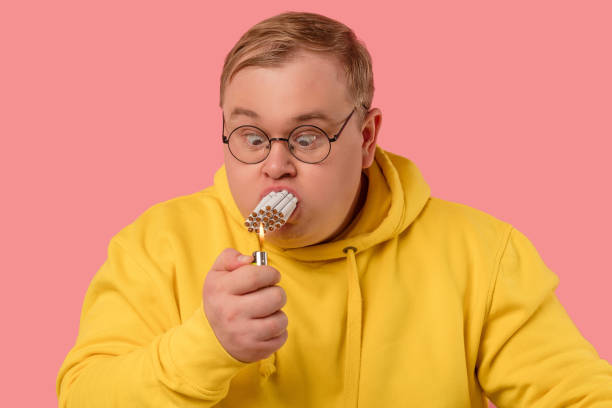 istock Stressed corpulent man trying to smoke a whole pile of cigarettes simultaneously 1227294939