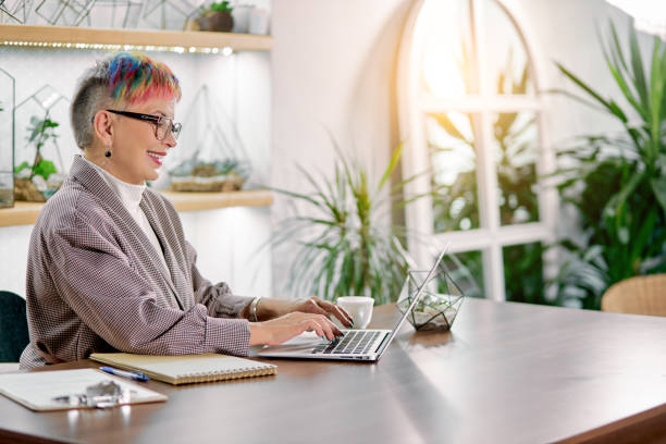 istock Side view on confident senior woman sitting with laptop 1227296409