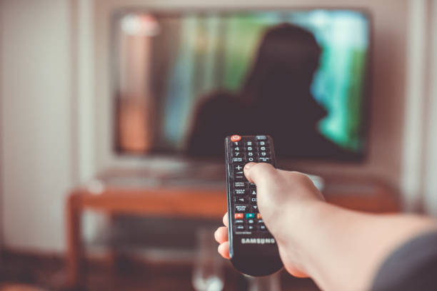 istock Close-up of hand with the remote control television and presses the button 1227297412