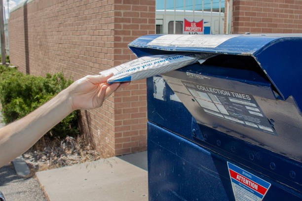 우체국 외부의 usps 우편 보관함에 이베이 봉투가 있는 우편 물패키지를 떨어뜨리는 남자 - us postal service 뉴스 사진 이미지