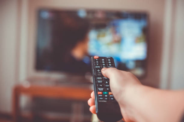istock Close-up of hand with the remote control television and presses the button 1227299518