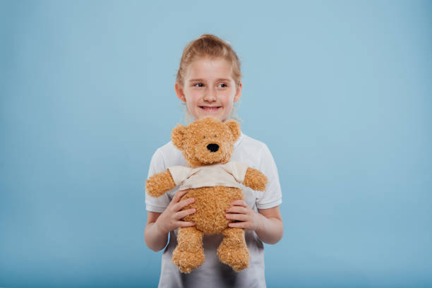 istock Cute little girl with plush bear in studio 1227303723