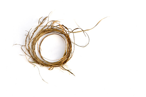 Ring made of natural fibers turned from dry grass on a white background