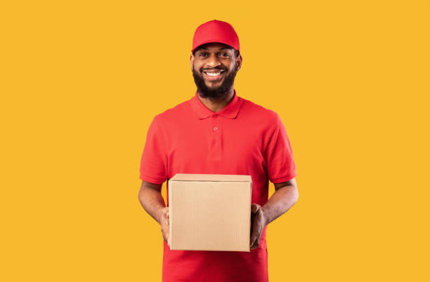 istock African American Delivery Man Holding Cardboard Box Standing In Studio 1227309463