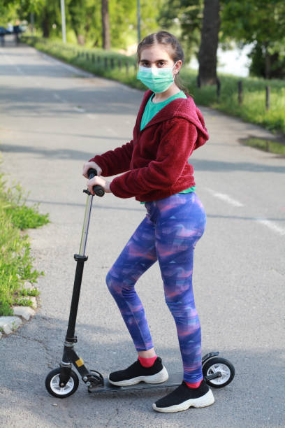 istock Girl on scooter with surgical face mask 1227309707