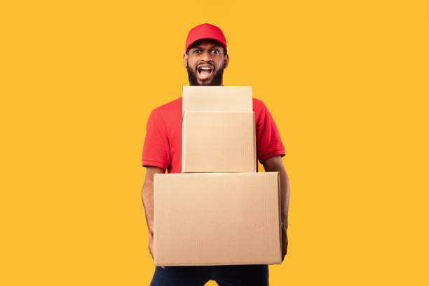 istock Overworked Courier Man Holding Cardboard Boxes Standing On Yellow Background 1227309851