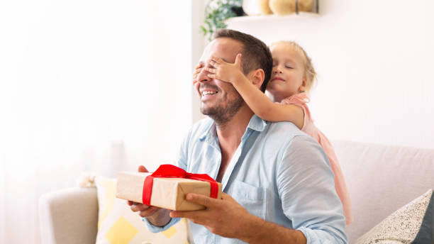 istock Excited girl holding her present with dad 1227309987