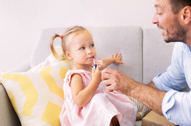 istock Cute girl applying makeup playing with dad 1227311359