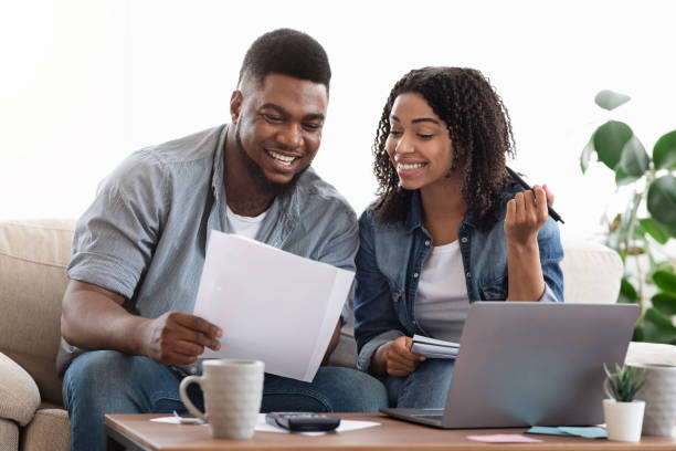 istock Black couple reading financial documentation at home while planning family budget 1227312180