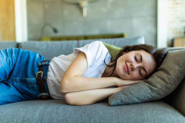 istock Young sleeping woman is lying on a pillow on a couch 1227313460