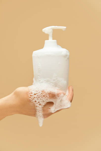 istock Personal Hygiene. Hand Covered With Foam Holding Liquid Soap Bottle On Beige Background. Washing Hands For Virus Prevention And Staying Healthy. 1227314499
