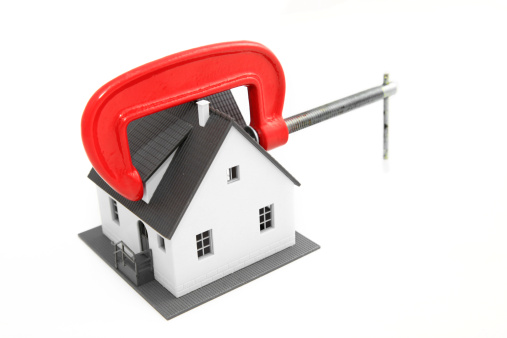 Red vice tool holding a mini house