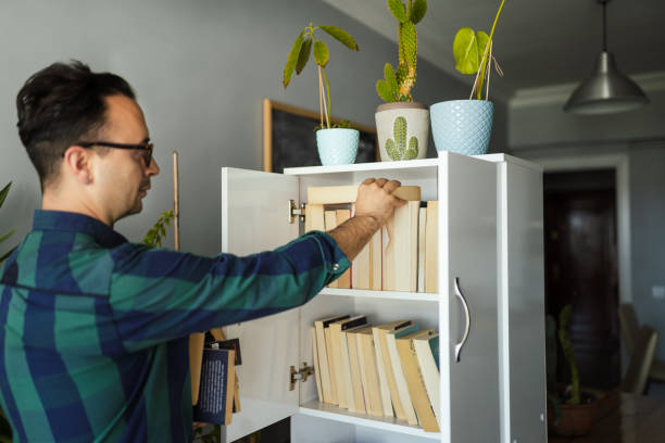 istock Millennial man organizing his book collections 1227319299
